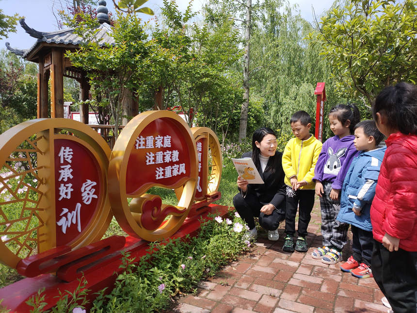 年輕的村紀檢委員正在給孩子們講述清廉家風故事。