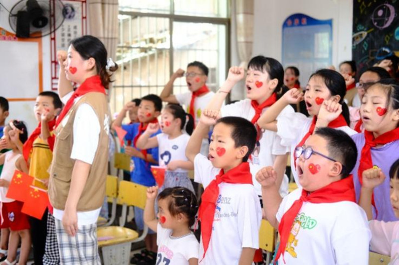 志愿者帶領(lǐng)孩子們面向隊旗莊嚴宣誓。