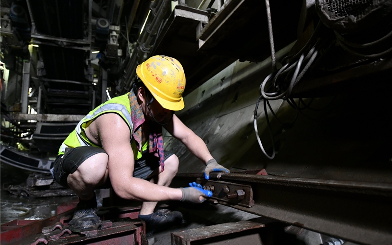 武漢地鐵19號(hào)線隧道中氣溫直逼40℃，中鐵十一局城軌公司一名工人正在進(jìn)行鋪軌作業(yè)。張璽攝