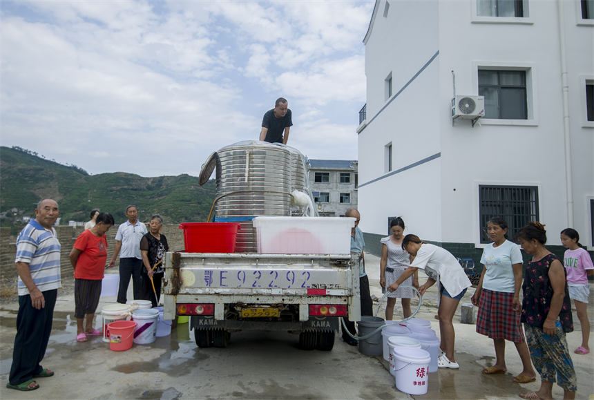 人大代表組織抗旱志原服務(wù)隊為村民干枯的茶葉抽水抗旱。