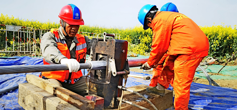 施工人員開展跨江導(dǎo)線接線管壓接作業(yè)。李健波攝