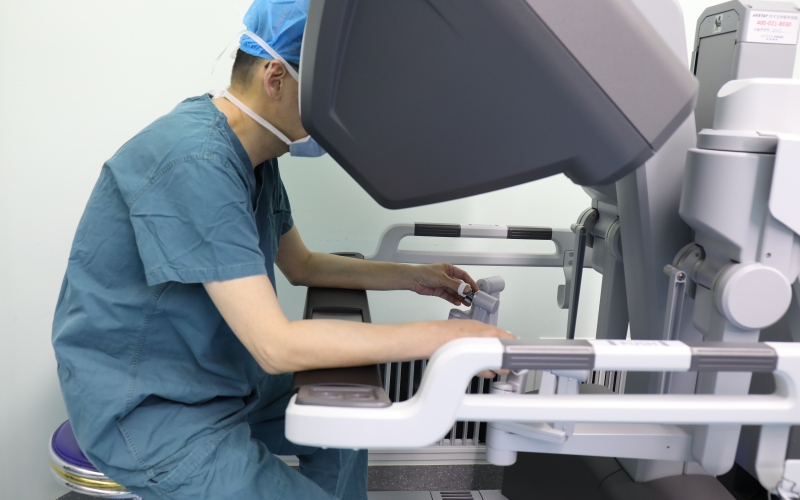 主刀醫(yī)師通過控制臺(tái)操作機(jī)器人進(jìn)行手術(shù)。代雨朦攝