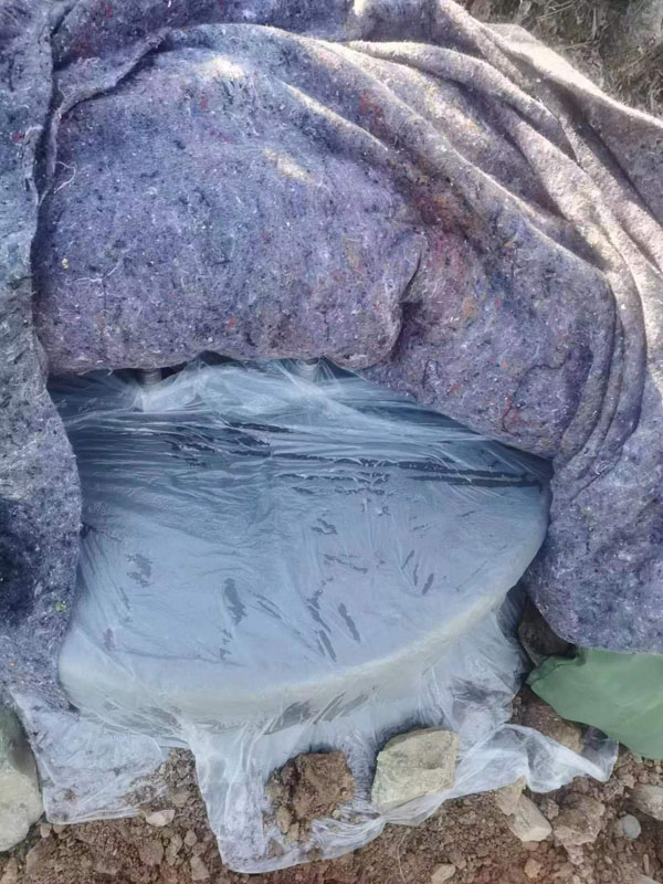 圖5：為保護(hù)電網(wǎng)鐵塔塔基，防止被凍壞，該公司項目工人將水泥澆筑后的塔基用保溫膜，棉氈，棉被層層包裹起來