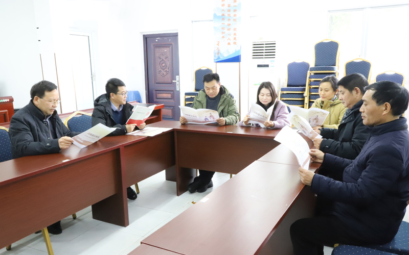 學(xué)校教師討論清廉學(xué)校建設(shè)宣傳冊(cè)。