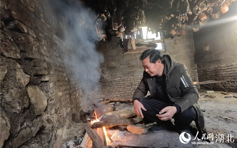 孫宜宗正在生火烤制熏肉。人民網(wǎng) 周雯攝