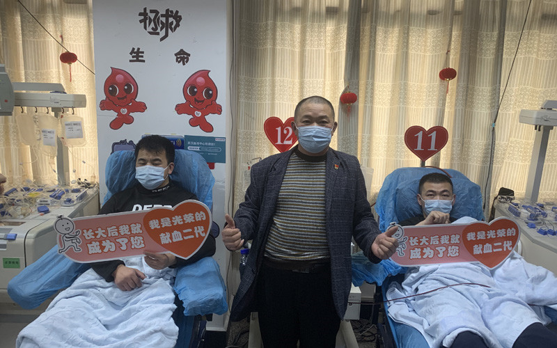 李光明（中）和他的獻血“接班人”。武漢血液中心供圖