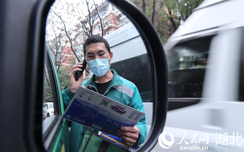  魯巷攬投站攬投員何亞飛電話聯(lián)系用戶預約投遞時間。人民網(wǎng) 肖璐欣攝