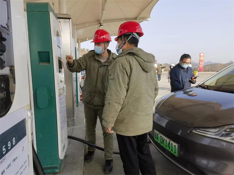 1月27日，在麻城中館驛服務(wù)區(qū)充電站，工作人員正在幫助用戶充電并宣傳安全操作知識。唐東琦攝