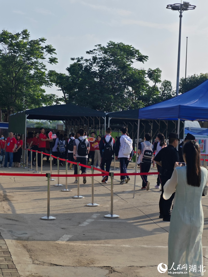 華中科技大學(xué)附屬中學(xué)考點外，老師紛紛舉著有祝福標(biāo)語的牌子，為考生加油。人民網(wǎng)記者 周雯攝