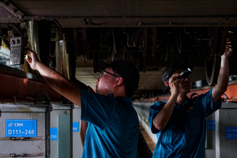 動(dòng)車組機(jī)械師在對(duì)列車進(jìn)行檢修。鄒政攝
