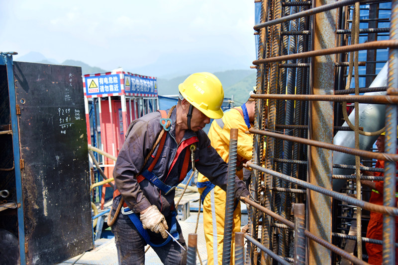 7月11日上午10點(diǎn)，十巫北高速控制性工程漢江特大橋南岸主塔130米高的施工現(xiàn)場(chǎng)，這里的氣溫直逼50度，大橋建設(shè)者正在進(jìn)行鋼筋綁扎施工。伍進(jìn)波攝