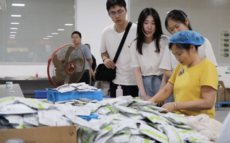 實踐隊員與工廠工人交談。