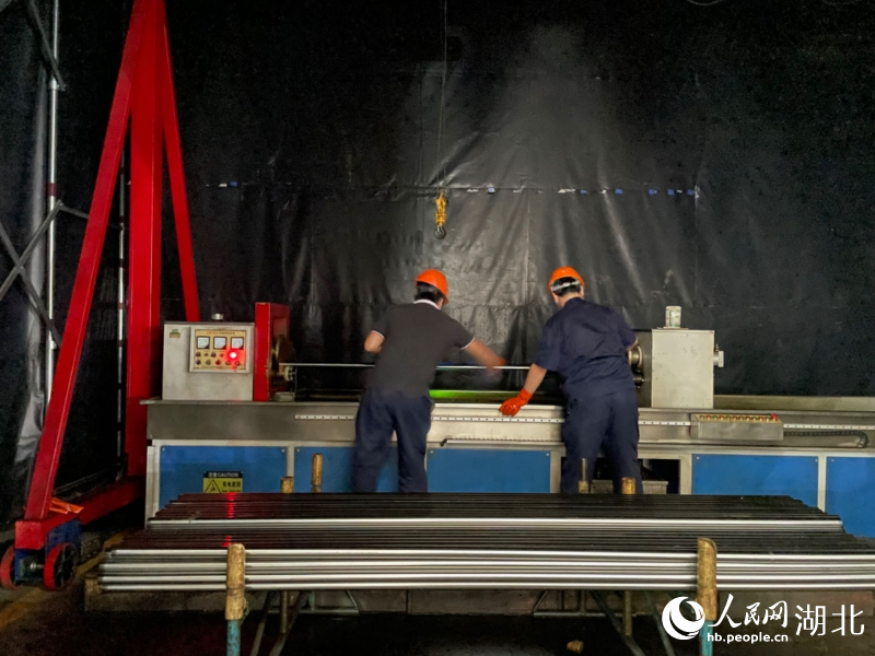 兩名質(zhì)檢員正在用熒光檢測螺栓表面是否有裂紋缺陷。人民網(wǎng)記者 周恬攝