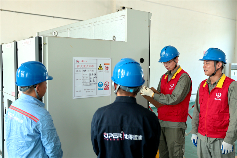 國(guó)網(wǎng)鄂州供電公司“鄂電紅馬甲”在唯品會(huì)物流園配電室內(nèi)檢查用電設(shè)備，確?！彪p11”物流園區(qū)可靠供電。戴佩攝