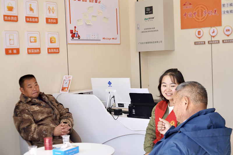 驛站工作人員和前來歇腳的群眾交流溝通。殷潔攝