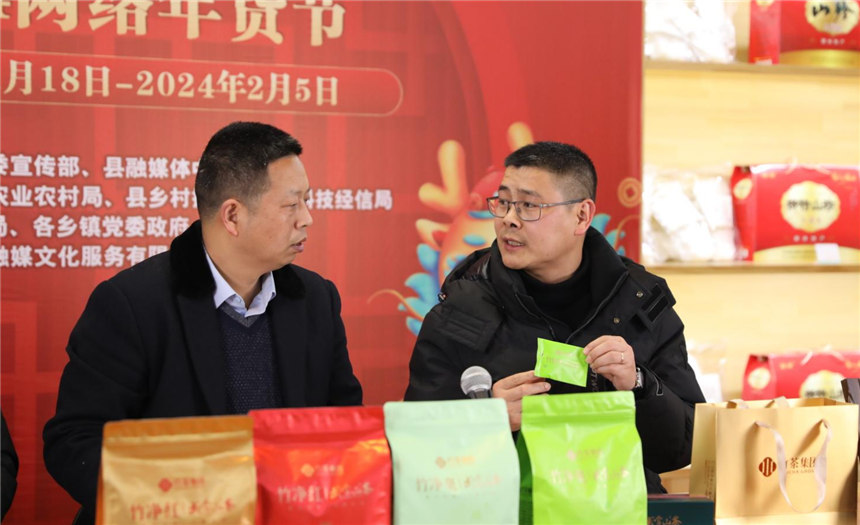竹山縣委宣傳部副部長、縣融媒體中心主任董武（左）向網(wǎng)友推薦竹山生態(tài)茶。
