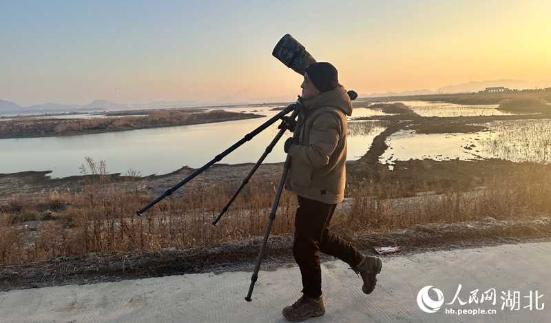  晏艮忠拿著攝影器材尋找拍攝點(diǎn)。人民網(wǎng)記者 張沛攝