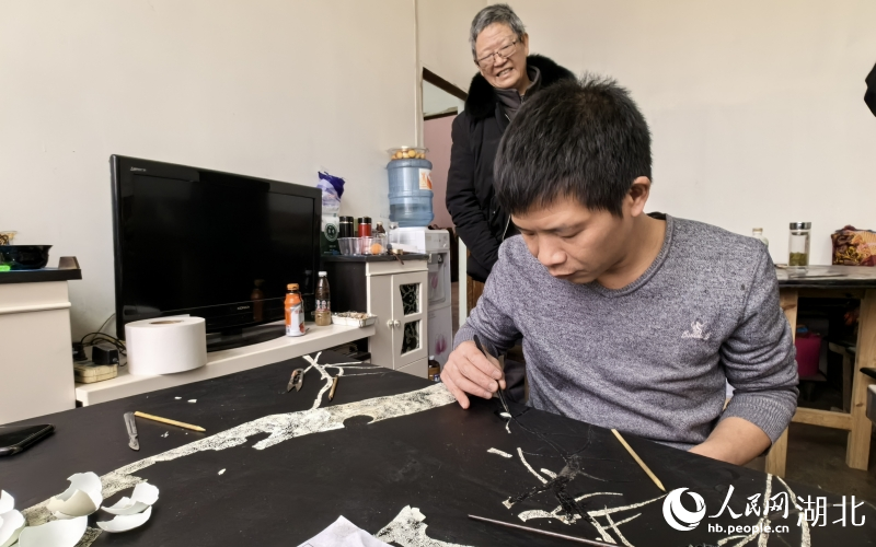 田亞正在趕制壩漆工藝品，師傅洪克儉在一旁指導(dǎo)。人民網(wǎng)記者 周雯攝