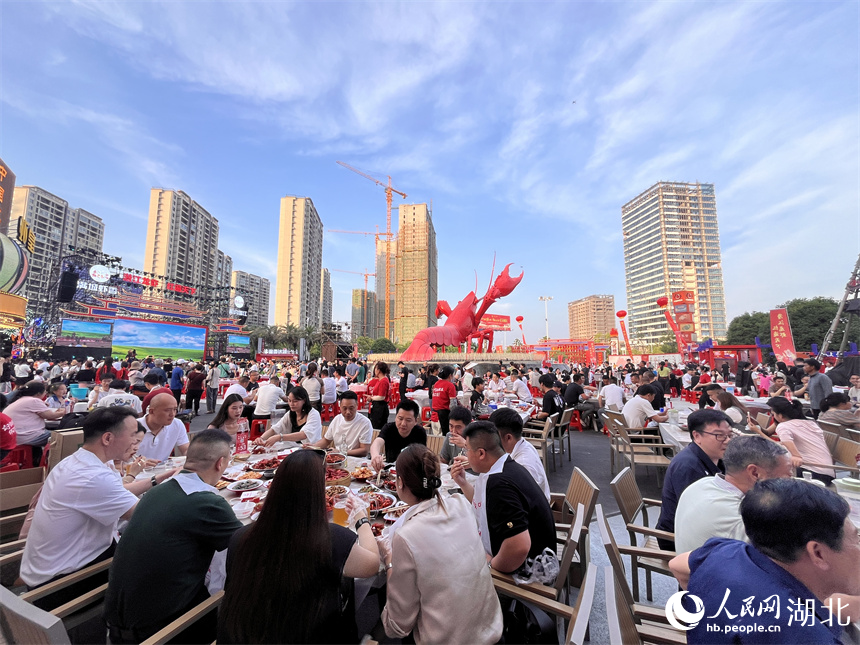 三五成群的食客手口并用，大快朵頤，品嘗著一盤盤色澤飽滿、醇香味美的小龍蝦。人民網(wǎng)記者 張雋攝 
