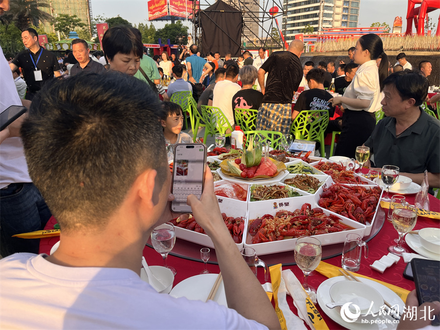 享受全蝦宴的食客先拍照發(fā)朋友圈。人民網(wǎng)記者 張雋攝