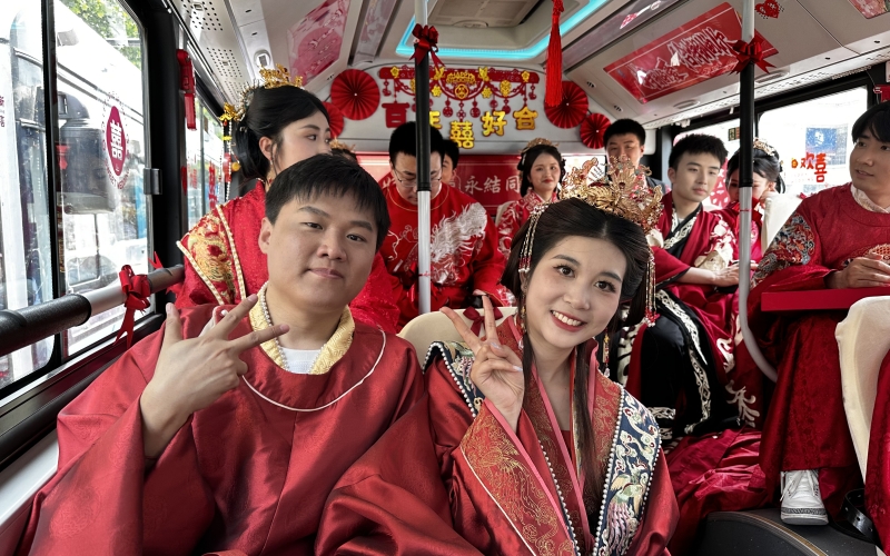 新人集體乘坐公交婚車，踐行低碳環(huán)保新風(fēng)尚。