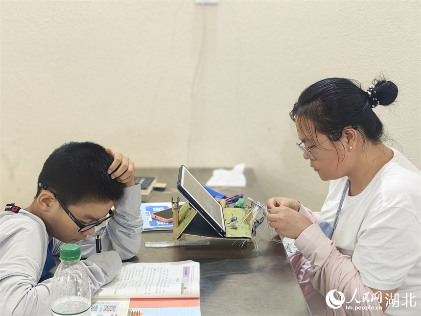 市民帶著小孩在納涼點(diǎn)讀書學(xué)習(xí)。人民網(wǎng)記者 肖璐欣攝