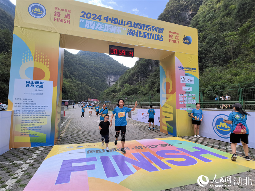 6.8公里群眾健身賽參賽選手帶著孩子通過終點。人民網(wǎng)記者 周雯攝