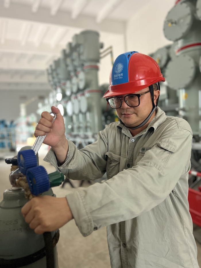 武漢鄧西220千伏變電站GIS區(qū)域，現(xiàn)場施工人員韓璐正在對已安裝完成的GIS設(shè)備進行混氣氣體的充入工作。韓璐攝