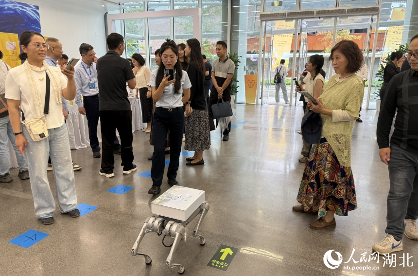 機(jī)器狗背上馱著大米產(chǎn)品，引人圍觀。人民網(wǎng)記者 周恬攝