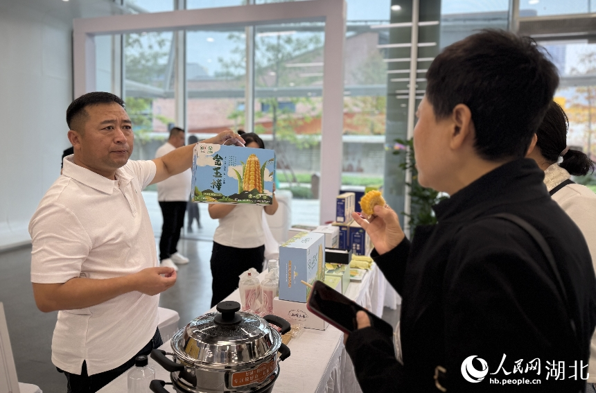 市民在武漢人民網(wǎng)“夢(mèng)幻靈境”AI展演中心品嘗來(lái)自吉林的玉米。人民網(wǎng)記者 周恬攝