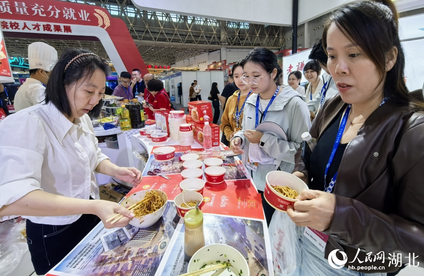 現(xiàn)場參觀者爭相品嘗武漢特產(chǎn)熱干面。人民網(wǎng)記者 周雯攝