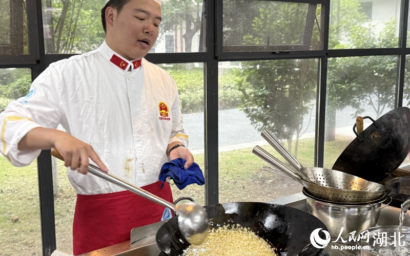 任課教師尉軒正在烹飪蒜蓉小龍蝦。人民網記者 張雋攝