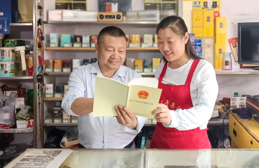 6月6日，襄陽(yáng)市襄州區(qū)煙草專賣局工作人員（左）深入零售商店開展普法宣傳工作。王建兵攝