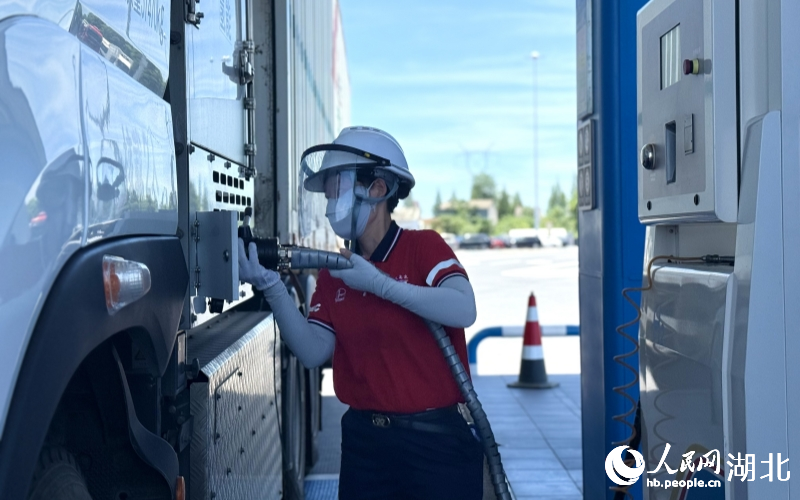 工作人員正在給氫能重卡加氫。人民網(wǎng)記者 周恬攝