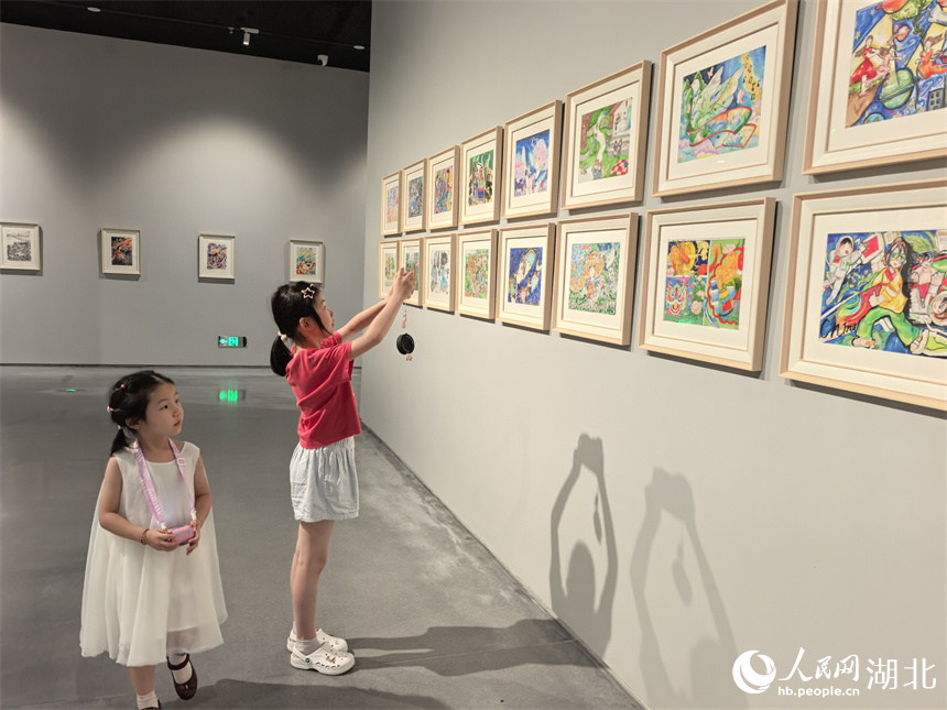 展覽現(xiàn)場，兒童拍照記錄自己喜愛的作品。