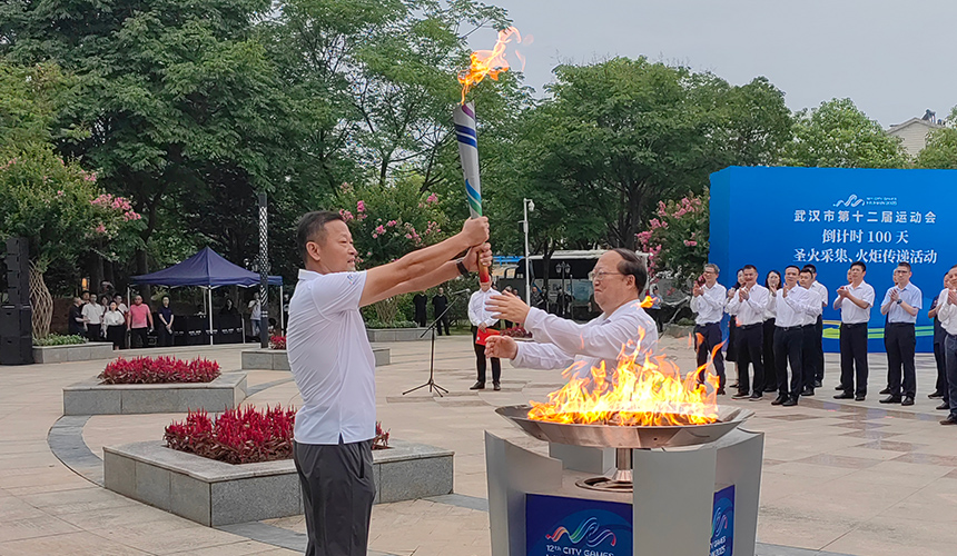 首棒火炬手常衛(wèi)魏從武漢市委常委、武漢經(jīng)濟(jì)技術(shù)開發(fā)區(qū)工委書記劉子清手中接過(guò)圣火。人民網(wǎng)記者 郭婷婷攝