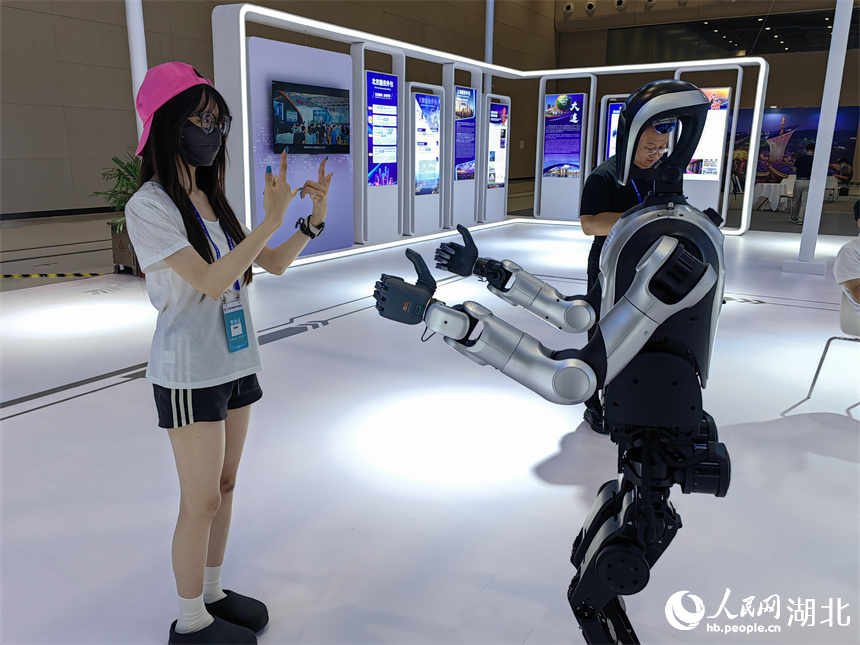 參會(huì)嘉賓與服務(wù)外包企業(yè)帶來(lái)的人形機(jī)器人互動(dòng)。人民網(wǎng)記者 郭婷婷攝