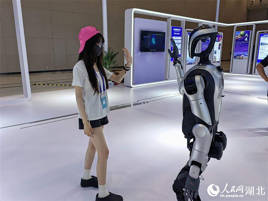 參會(huì)者與服務(wù)外包企業(yè)帶來的人形機(jī)器人互動(dòng)。人民網(wǎng)記者 郭婷婷攝