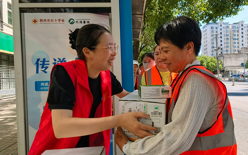 志愿者為環(huán)衛(wèi)工人送防暑物品。