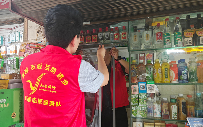 志愿者為銀發(fā)零售戶安裝推拉防蚊簾。