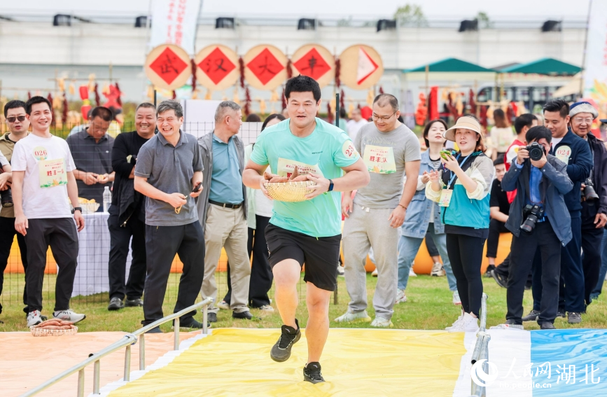 武漢2025中國農(nóng)民豐收節(jié)農(nóng)趣運動會賽場上，選手們端著紅薯接力奔跑。人民網(wǎng)記者 郭婷婷攝