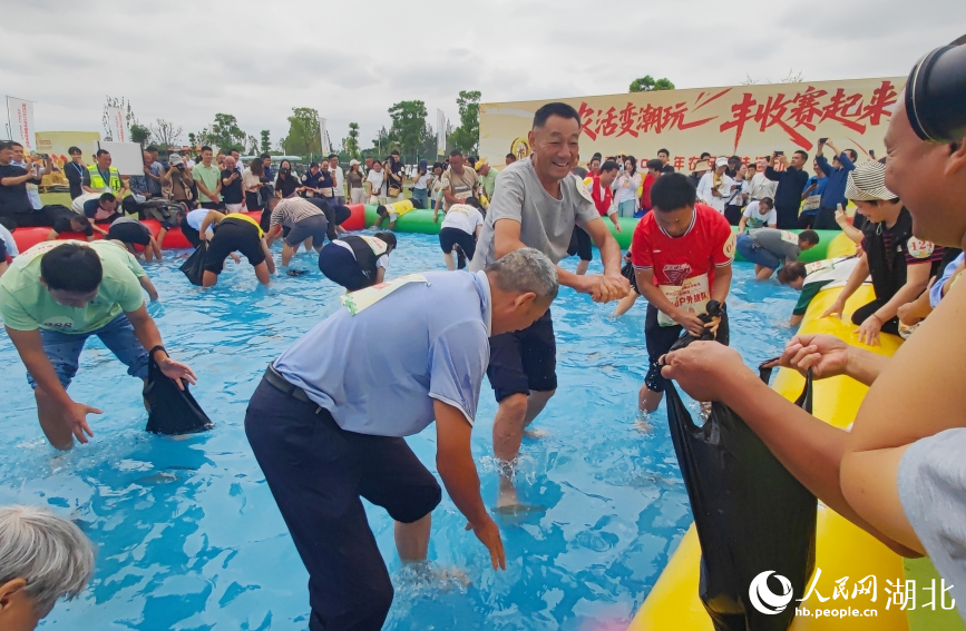 “魚躍豐年”比賽中，選手們徒手摸魚，比拼速度與眼力。人民網(wǎng)記者 郭婷婷攝