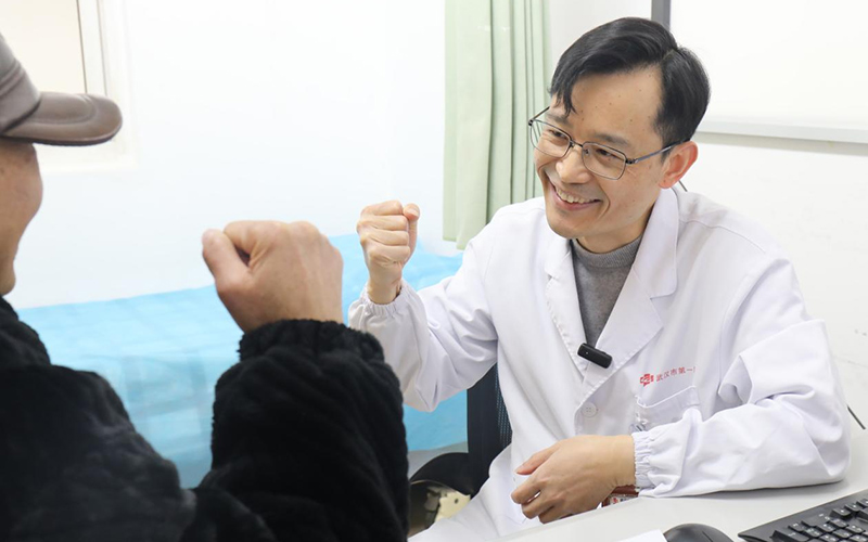 感動(dòng)“醫(yī)”瞬間二等獎(jiǎng)作品《胸外科專家門診診室內(nèi)，主任醫(yī)師羅東與患者鼓勁加油》。代雨朦攝