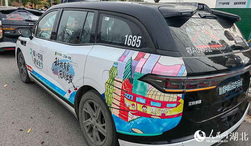 孤獨(dú)癥兒童的畫作被印上了無人駕駛車輛。人民網(wǎng)記者 郭婷婷攝