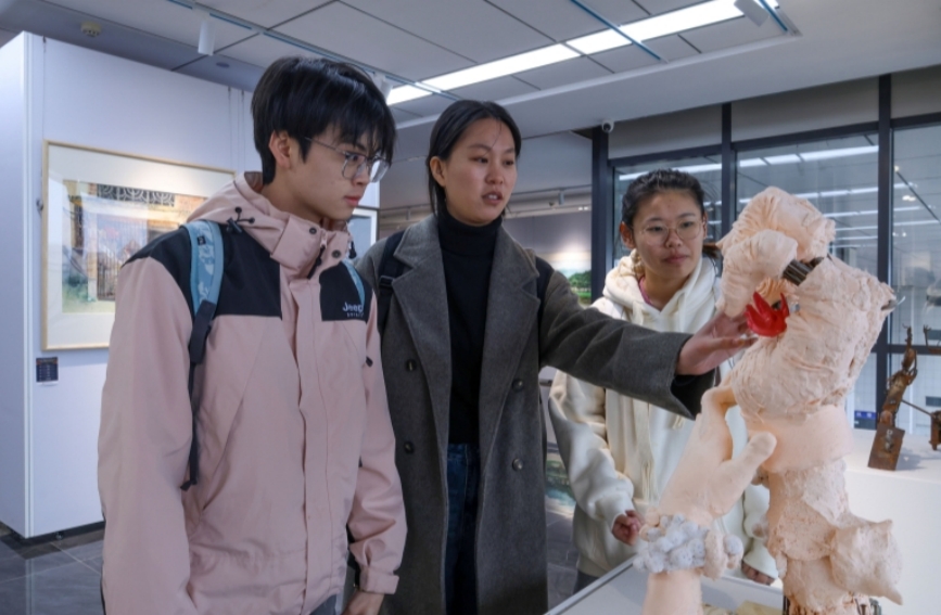 學(xué)生們參觀美術(shù)作品展。陳雯茜攝 