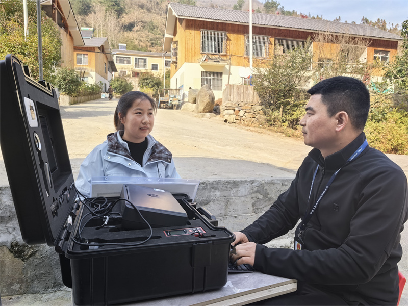 專賣證件管理人員正在現(xiàn)場(chǎng)為鄉(xiāng)村客戶辦證。郝敬帆攝