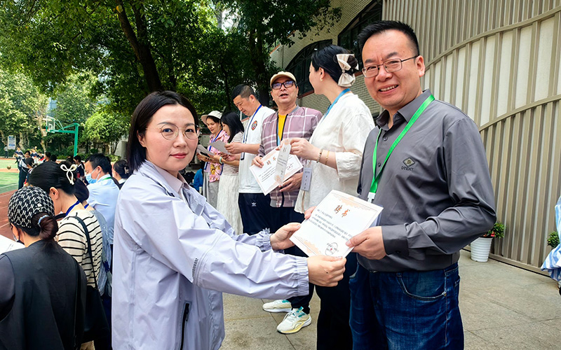 武漢市第十二初級中學(xué)校長孫曉潔為食堂膳食監(jiān)督委員會家長委員頒發(fā)聘書。