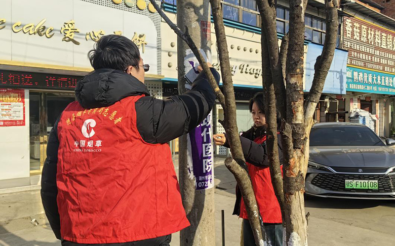 志愿者們幫忙清理違規(guī)小廣告。