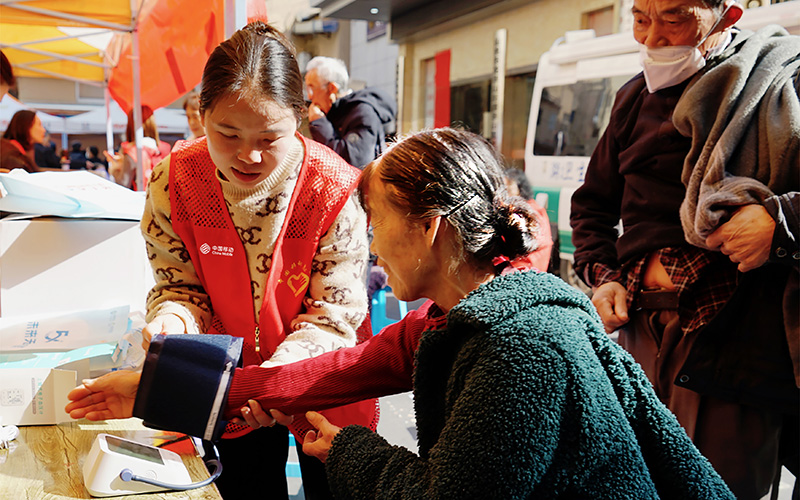 中國移動工作人員正細(xì)心地為老年人測量血壓。